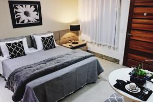 um quarto com uma cama grande e uma mesa em Flat's Refúgio Vip em Cabo Frio