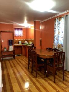 a kitchen and dining room with a wooden table and chairs at Cardo Homestay Siargao in General Luna