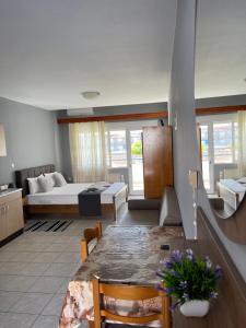 Sala de estar con cama y mesa de comedor en Artemis Hotel Apartments en Keramotí