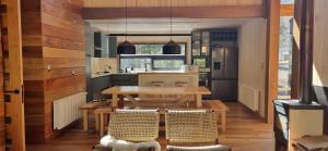 a kitchen with a wooden table and a dining room at Refugio PIREN, Corralco, Hot Tub y nieve in Curacautín +22 photos