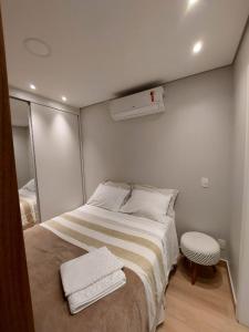 een kleine slaapkamer met een bed en een spiegel bij VN CASA TOPÁZIO - VILA MARIANA in Sao Paulo
