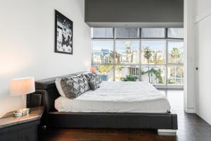 a bedroom with a bed and a large window at Heaven on Hollywood Furnished Apartments in Los Angeles