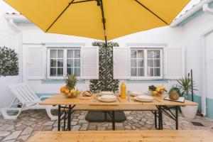 una mesa con una sombrilla amarilla en el patio en Best Houses 26: Baleal Beach Front Retreat, en Ferrel