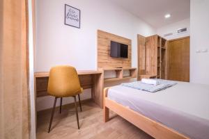 a bedroom with a bed and a desk and a television at Zoe Pirot in Pirot