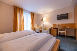um quarto de hotel com uma cama e uma secretária em Landhotel Atzmüller em Waxenberg