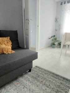 a living room with a couch and a rug at Pigeon apartment in Kuldīga