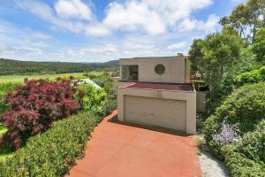 un edificio con un garage in mezzo a un giardino di Panoramic Views ad Aireys Inlet