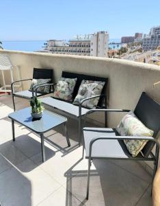trzy krzesła i stoły na balkonie z widokiem w obiekcie LUX. FRONTBEACH-TERRACE. 5 POOLS.TV. 2 A.C.NETFLIX w mieście Benalmádena