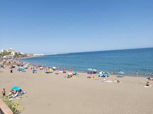 un gran grupo de personas en una playa en LUX. FRONTBEACH-TERRACE. 5 POOLS.TV. 2 A.C.NETFLIX en Benalmádena