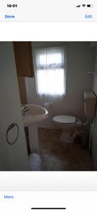 baño con lavabo y aseo y ventana en i13 the chase caravan park, en Ingoldmells