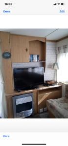 ein Wohnzimmer mit einem Flachbild-TV auf einem Tisch in der Unterkunft i13 the chase caravan park in Ingoldmells