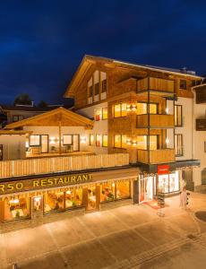 un edificio con un restaurante delante de él por la noche en Apart Simon Seefeld, en Seefeld in Tirol