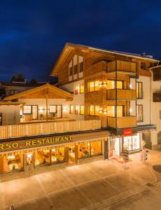 a building with a restaurant in front of it at night at Apart Simon Seefeld in Seefeld in Tirol