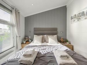 um quarto com uma cama grande e toalhas em Alde Lodge - 5 mins from beach with EV Point em Aldeburgh