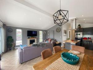 uma sala de estar com um sofá e uma mesa em Alde Lodge - 5 mins from beach with EV Point em Aldeburgh