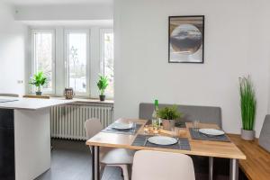 Il comprend une cuisine et une salle à manger avec une table et des chaises en bois. dans l'établissement Quartier Mehrblick, à Willingen