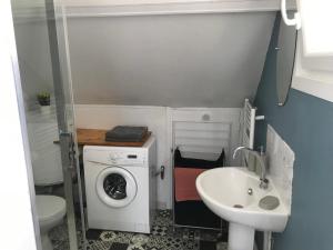 une petite salle de bains avec un lave-linge et un lavabo dans l'établissement Ambleteuse appartement vue mer, à Ambleteuse