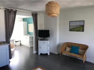 - un salon avec une télévision et un canapé dans l'établissement Ambleteuse appartement vue mer, à Ambleteuse