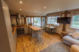 eine Küche und ein Wohnzimmer mit einem Sofa und einem Tisch in der Unterkunft Halfmoon Lodge @ Knights Hole wheelchair access in Cranbrook