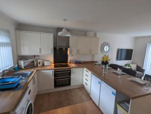 a kitchen with white cabinets and a stove top oven at THE KILSYTH,detached bungalow Warrington in Warrington