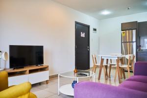 a living room with a purple couch and a tv at The Gallery Exquisite in Accra