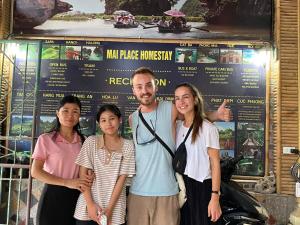 eine Gruppe von Menschen, die vor einem Schild stehen in der Unterkunft Mai Place Homestay in Ninh Bình