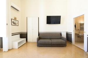 a living room with a chair and a tv at Residenza Molinari Suite in Naples