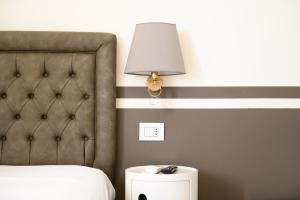 a bedroom with a bed and a lamp next to a headboard at Residenza Molinari Suite in Naples