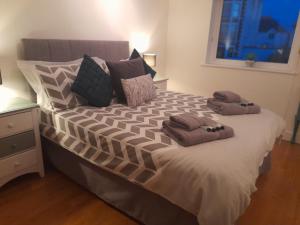 sypialnia z dużym łóżkiem z dwoma ręcznikami w obiekcie Fistral beach apartment w Newquay
