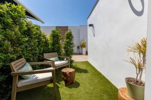 a small garden with two chairs and green plants at Lo hotel del poblet in El Poblenou del Delta