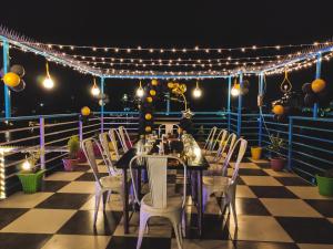a table and chairs on a deck with lights at Hotel Lake Bridge in Udaipur