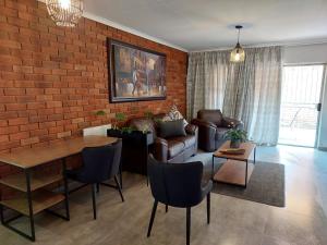 a living room with a brick wall at UStay Apartment - Westdene in Bloemfontein