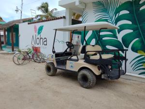 une voiturette de golf garée devant un bâtiment dans l'établissement Casa aloha-Isla Holbox, à Holbox
