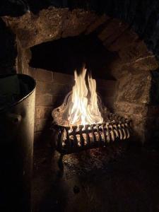 a fireplace with a fire in a brick oven at Cross Keys Inn in Penrith