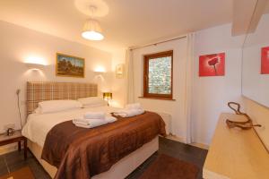 a bedroom with a bed with two towels on it at White Lodge Apartments in Mawgan Porth