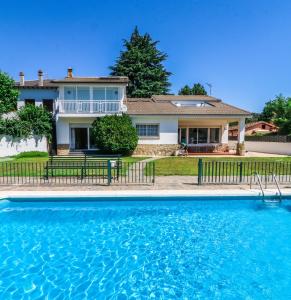 a house with a swimming pool in front of a house at Casa Rural El Retiro de Gredos by RetiroRural in Arenas de San Pedro