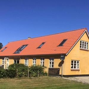 a yellow and orange house with a red roof at Istrup gammel skole in Bedsted Thy