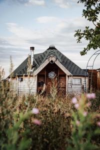 an old house in the middle of a field at Mad Hatters Glamping & Campsite in Ely