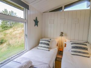 two beds in a small room with a window at Top Of The World Lodge in Aberdyfi