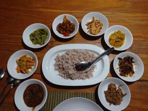 una mesa llena de platos de comida con arroz y verduras en 99 River cabana, en Udawalawe