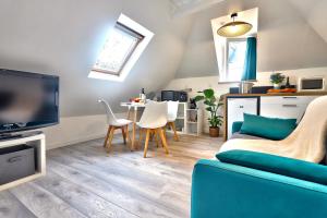 salon z kanapą, telewizorem i stołem w obiekcie Ty Koant au coeur du Guilvinec - Wifi inclus - Draps et serviettes inclus w mieście Guilvinec
