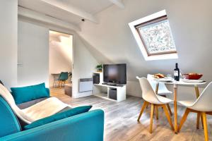 salon z niebieską kanapą i stołem w obiekcie Ty Koant au coeur du Guilvinec - Wifi inclus - Draps et serviettes inclus w mieście Guilvinec