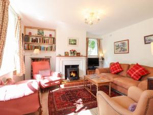 uma sala de estar com sofás e uma lareira em Warren Cottage em Leavenheath