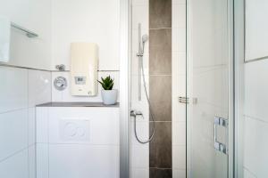 baño blanco con ducha y puerta de cristal en Grömitz Center II Wohnung 40 en Grömitz