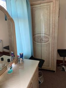a bathroom with a sink and a mirror and a cabinet at Busy Bee - Guest House - Self Service in Leigh