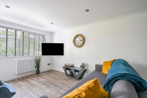 een woonkamer met een bank en een flatscreen-tv bij 51 Fernhill Heights in Bridport