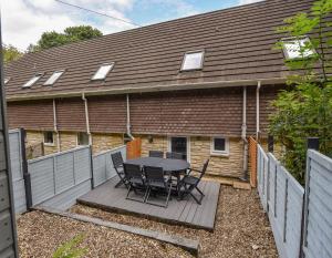 a table and chairs on a wooden deck in front of a house at 51 Fernhill Heights in Bridport