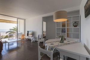 a dining room with a table and a room with a view at LETS HOLIDAYS Beach front apartment in Gavà Mar, Pine Beach in Gavà