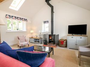 a living room with a couch and a tv at Barley Cottage in Cheriton