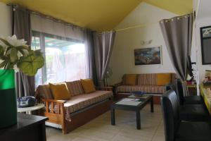 a living room with two couches and a table at Golondrina 17 - Bungalow con giardino a Matagorda - Fronte mare - Aria condizionata - Piscina in Los Pocillos